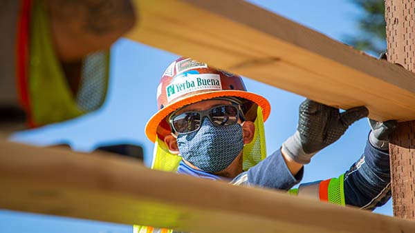 Construction worker using safety harness hook on belt